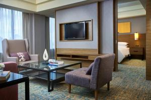 新山Renaissance Johor Bahru Hotel的一间客厅,客厅配有沙发和电视,位于酒店的房间