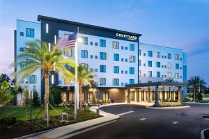 CanaCourtyard by Marriott Port St. Lucie Tradition的棕榈树酒店前的 ⁇ 染