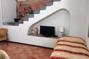 PuntalazzoVilla Alessio - Case Vacanza con Piscina sull'Etna的一间带电视和楼梯的客厅