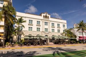 迈阿密海滩Marriott Vacation Club®, South Beach   的一座带桌子和遮阳伞的大型白色建筑