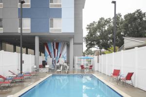 坦帕TownePlace Suites by Marriott Tampa South的一座带椅子的游泳池以及一座建筑