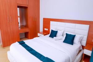 MeruLuxe Furnished Apartments Unit 3的卧室配有带蓝色枕头的大型白色床