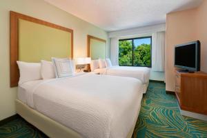 南本德SpringHill Suites Mishawaka-University Area的酒店客房设有两张床和电视。