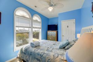 翡翠岛Waterfront Emerald Isle Home with Dock Access!的蓝色的卧室设有床和窗户