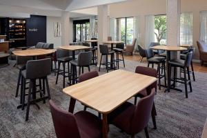 达拉姆杜克大学达勒姆市中心万怡酒店的餐厅设有桌椅和窗户。