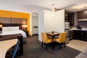 里贾纳里贾纳万豪住宅酒店的酒店客房带一张床、一张桌子和椅子