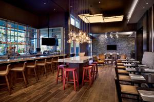 罗利州景傲途格精选酒店的餐厅设有酒吧,配有桌椅