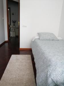 坎巴多斯O PISIÑO的一间卧室配有一张床和地毯