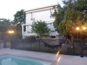 孔夫朗-圣奥诺里讷Logement à 30min de la défense avec piscine privative的房屋的背景是围栏和游泳池