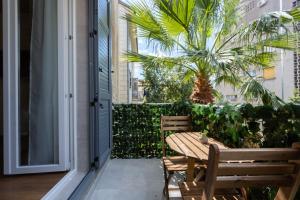 斯普利特Luxury Rooms Fetivi的一个带木桌和椅子的庭院和棕榈树