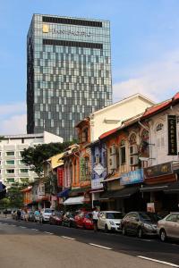 新加坡Pan Pacific Serviced Suites Beach Road, Singapore的一条城市街道,后面有一座高大的建筑