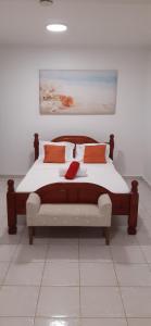 大博格Résidence KAYA, Marie-Galante的一间卧室配有一张带橙色枕头的大床