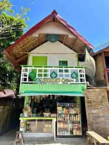 BuruangaLorenza's Cottage 1的一间拥有绿色和白色建筑的小商店