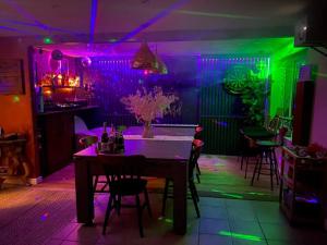 诺丁汉Cheerful 3-bed detached home的一间设有桌子和紫色及绿灯的用餐室