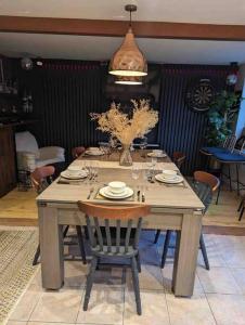 诺丁汉Cheerful 3-bed detached home的一张带椅子的木桌和花瓶