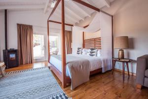 圣特奥托纽Paraiso Escondido的一间卧室配有一张天蓬床和蓝色地毯