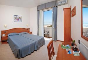 西尼加利亚阿根廷娜酒店的一间卧室配有一张床、一张桌子和一个窗户。