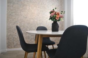 马拉加Victoria Flat F&M Moderno, acogedor y céntrico的一张桌子,有三把椅子和花瓶