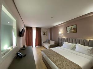 地拉那Doanesia Premium Hotel & Spa的酒店客房,配有床和电视