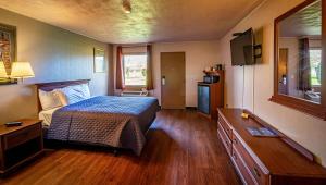 新坎伯兰Magnuson Grand Harrisburg的一间卧室配有一张床和一台电视
