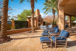 彭萨科拉Courtyard by Marriott Pensacola Downtown的庭院里一排椅子和棕榈树