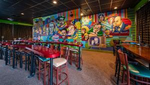 新坎伯兰Magnuson Grand Harrisburg的一间带桌椅和壁画的餐厅