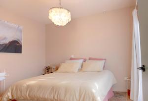 格雷敦The Castle的卧室配有白色的床和吊灯。