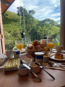 圣安东尼奥-杜皮尼亚尔Chalés Ceuci的餐桌,早餐包括面包和橙汁