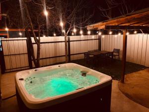 阿尔伯克基Prickly Pear at Cactus Flower-HOT TUB-Pet Friendly-No Pet Fees!的庭院内的热水浴池,配有桌子和灯