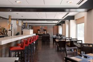 波士顿温德姆波士顿笔架山酒店的一间设有红色桌椅的餐厅和一间酒吧