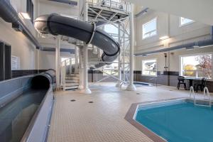WarmanDays Inn & Suites by Wyndham Warman Legends Centre的一座带滑梯的室内游泳池