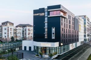 克雷泰伊Courtyard by Marriott Paris Creteil的一座黑色的建筑,旁边有一个标志