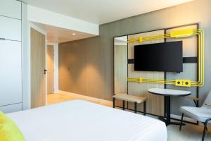 克雷泰伊Courtyard by Marriott Paris Creteil的一间卧室配有一张床和一台平面电视