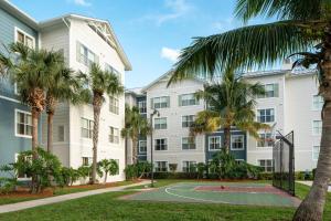 卡纳维拉尔角Residence Inn by Marriott Cape Canaveral Cocoa Beach的公寓大楼设有篮球场和棕榈树