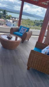 里奥圣胡安Apartamentos La Torre的阳台设有藤椅和一张桌子,享有海景。