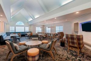 萨拉索塔Residence Inn by Marriott Sarasota Bradenton的大房间设有桌椅和电视