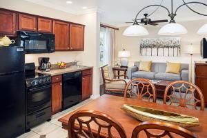 圣露西港Sheraton PGA Vacation Resort Port St Lucie的厨房以及带桌椅的起居室。