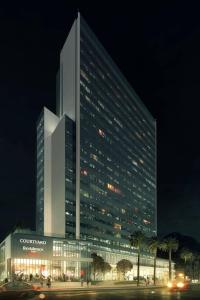 里约热内卢里约热内卢巴拉达蒂茹卡万怡酒店的一座大型建筑,在晚上有车在前面