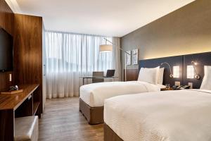 里约热内卢里约热内卢巴拉达蒂茹卡万怡酒店的酒店客房配有两张床和一张书桌