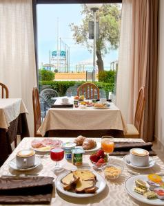 西尼加利亚阿根廷娜酒店的一张桌子,上面有早餐食品,窗户