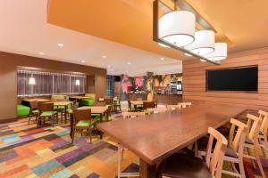 罗宾逊镇匹兹堡机场/罗宾逊乡费尔菲尔德客栈的用餐室配有大型木桌和椅子