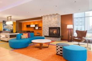 罗宾逊镇匹兹堡机场/罗宾逊乡费尔菲尔德客栈的客厅配有蓝色的家具和壁炉