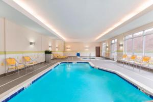 罗宾逊镇匹兹堡机场/罗宾逊乡费尔菲尔德客栈的游泳池位于酒店带椅子的客房内,游泳池