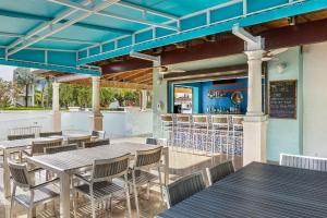迈阿密多拉万豪别墅酒店的一个带桌椅的庭院和一间酒吧