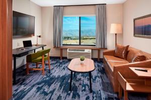印地欧Fairfield by Marriott Inn & Suites Indio Coachella Valley的酒店客房设有沙发、书桌和桌子。