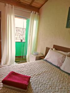 圣托梅-达斯莱特拉斯Suites em São Thomé das Letras的一间卧室配有一张大床,上面有红色毛巾