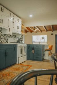 阿尔伯克基Casa Charleston-3BR-2Bath-HOT TUB-Pet Friendly-No Pet Fees!的厨房配有绿色橱柜和白色炉灶烤箱。