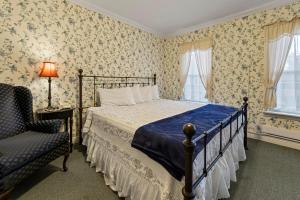 普莱西德湖普莱西德湖村派恩斯旅馆的一间卧室配有一张床、一把椅子和窗户。