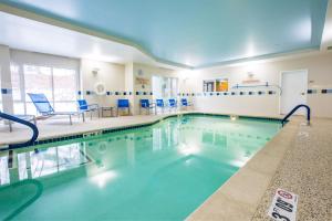 吉尔福特吉尔福德万豪广场套房酒店的大楼内带蓝色椅子的游泳池