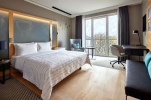 汉堡汉堡艾美酒店的配有一张床、一张书桌和一扇窗户的酒店客房